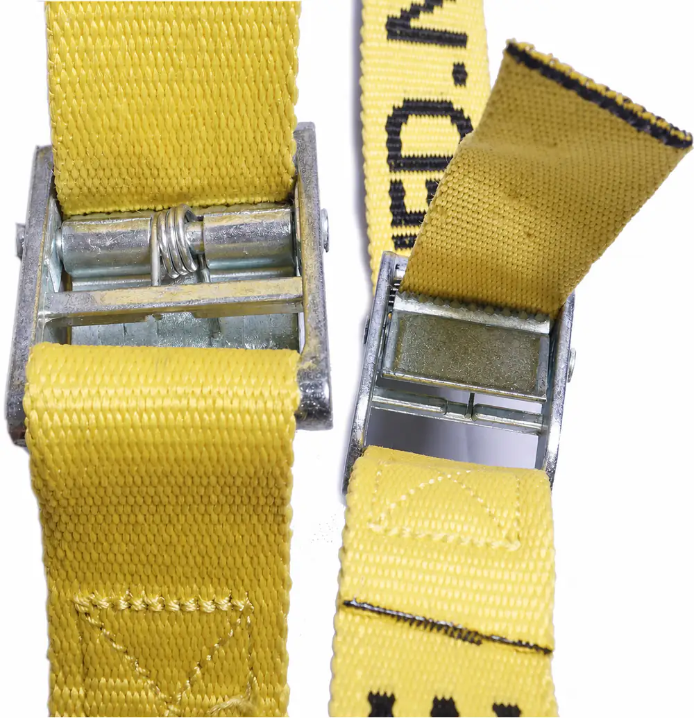 Two yellow cam buckle interfaces expose spring, tooth plate, webbing route and cut-end condition for inspection.