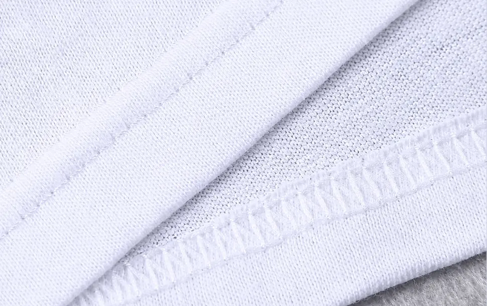 White knit fabric with folded hem and overlock stitching shown at close range
