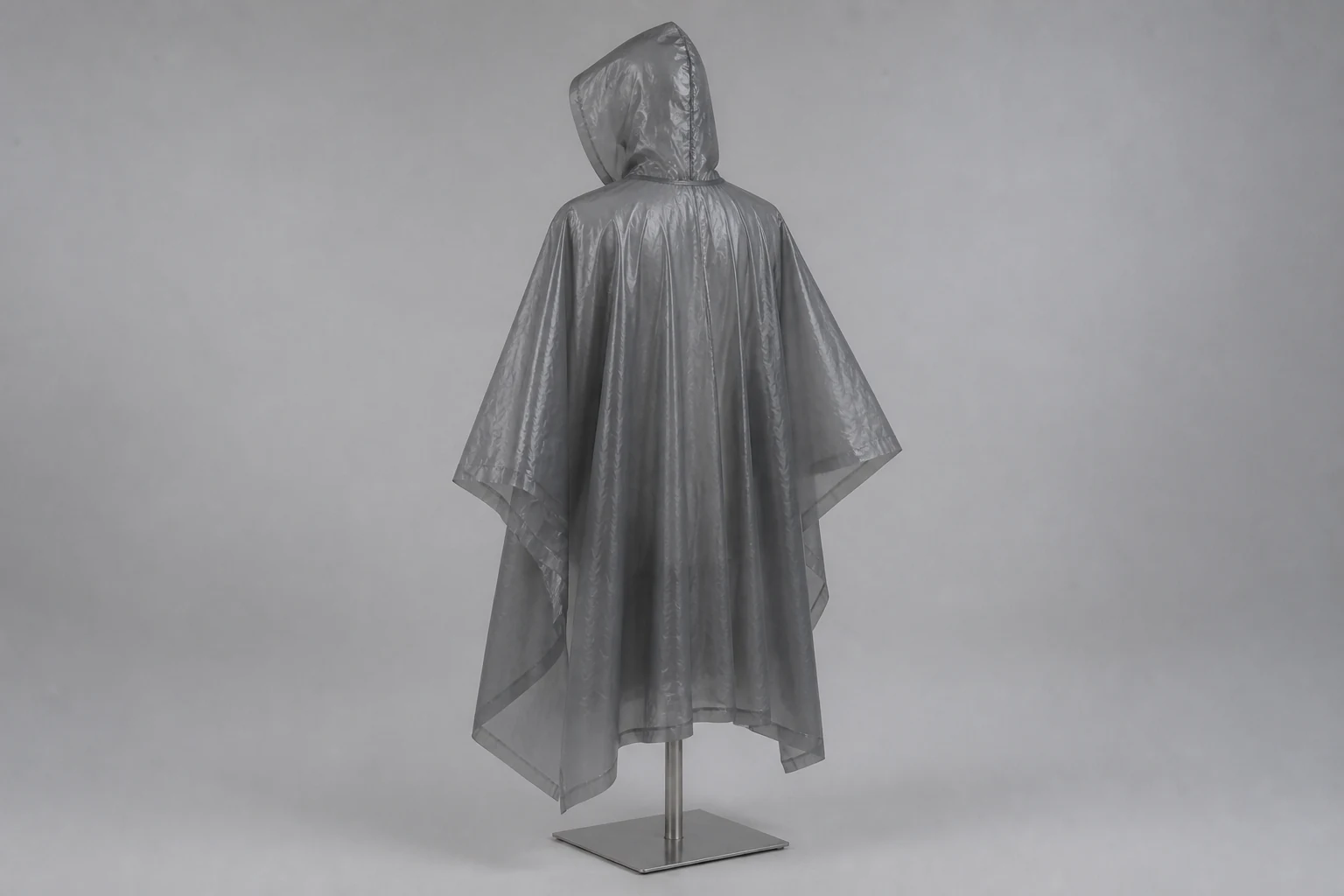 Complete charcoal nonwoven rain poncho shown from the rear on a neutral mannequin