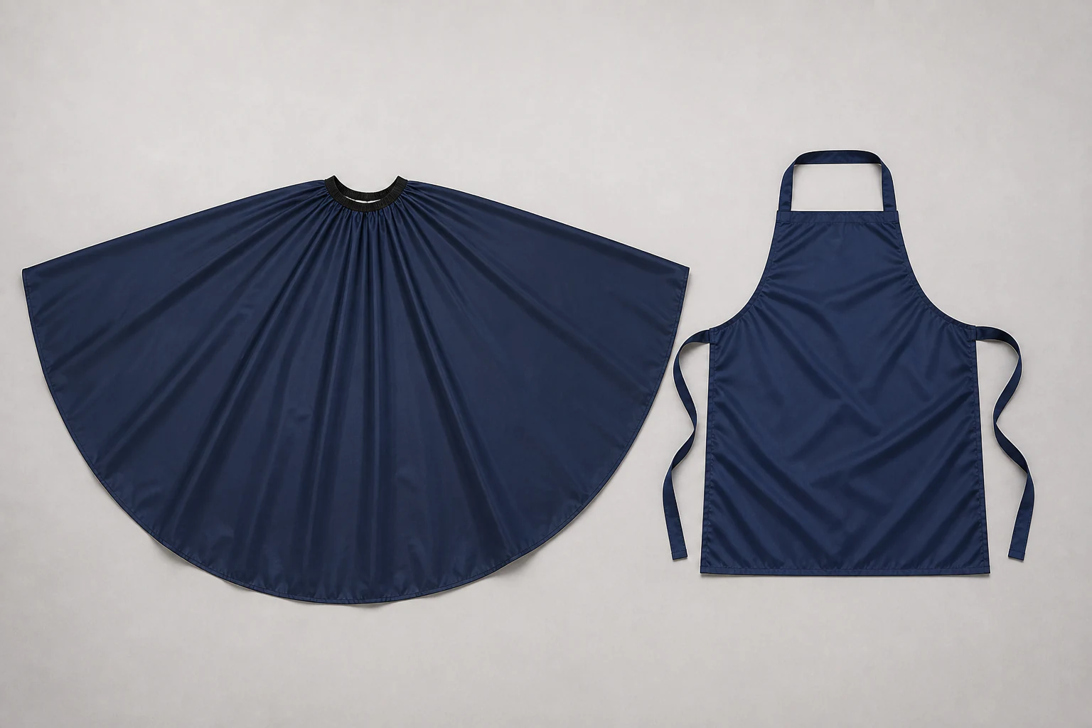 Complete navy work cape and bib apron laid separately for coverage-form comparison