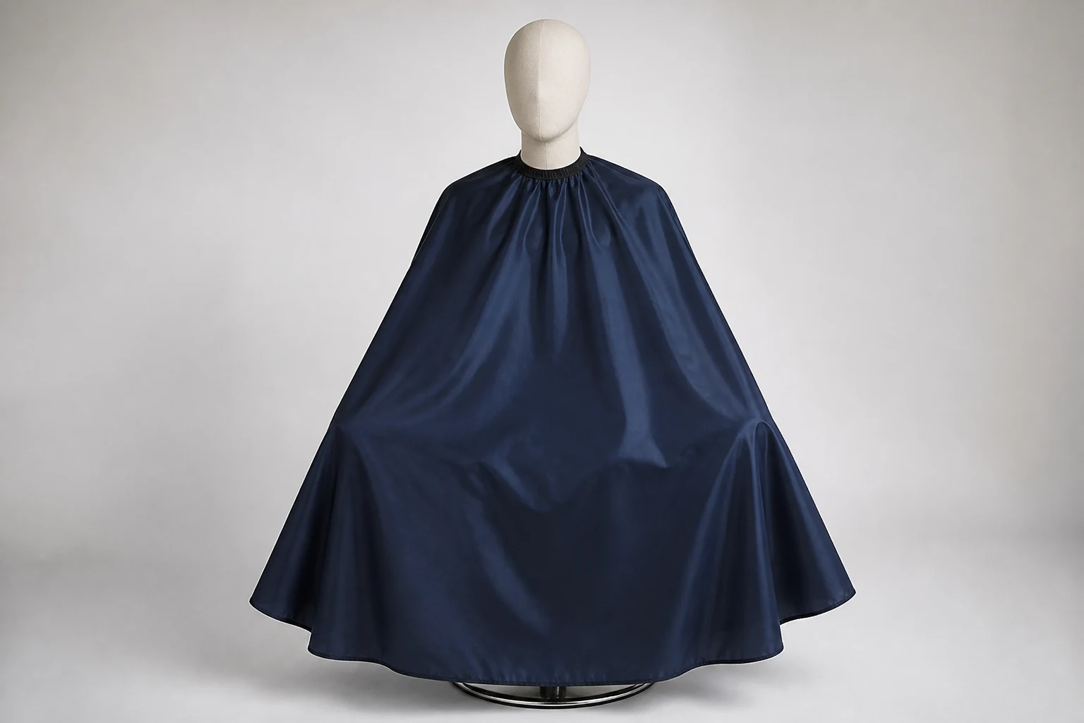 Complete dark navy work cape displayed on a neutral seated mannequin with the full lower edge visible