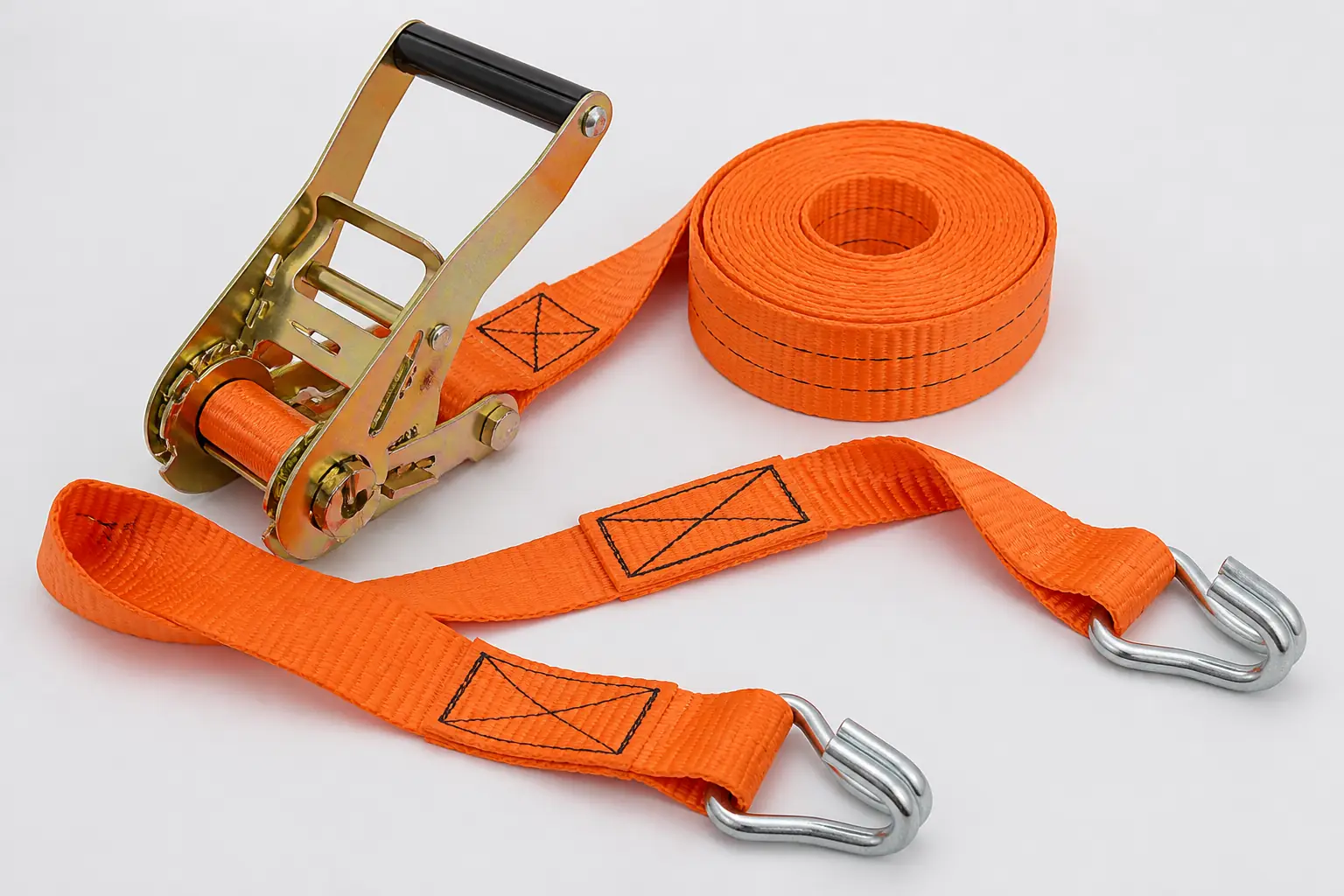 Complete orange ratchet tie-down assembly arranged to show webbing, tensioner, stitched ends and compatible hooks